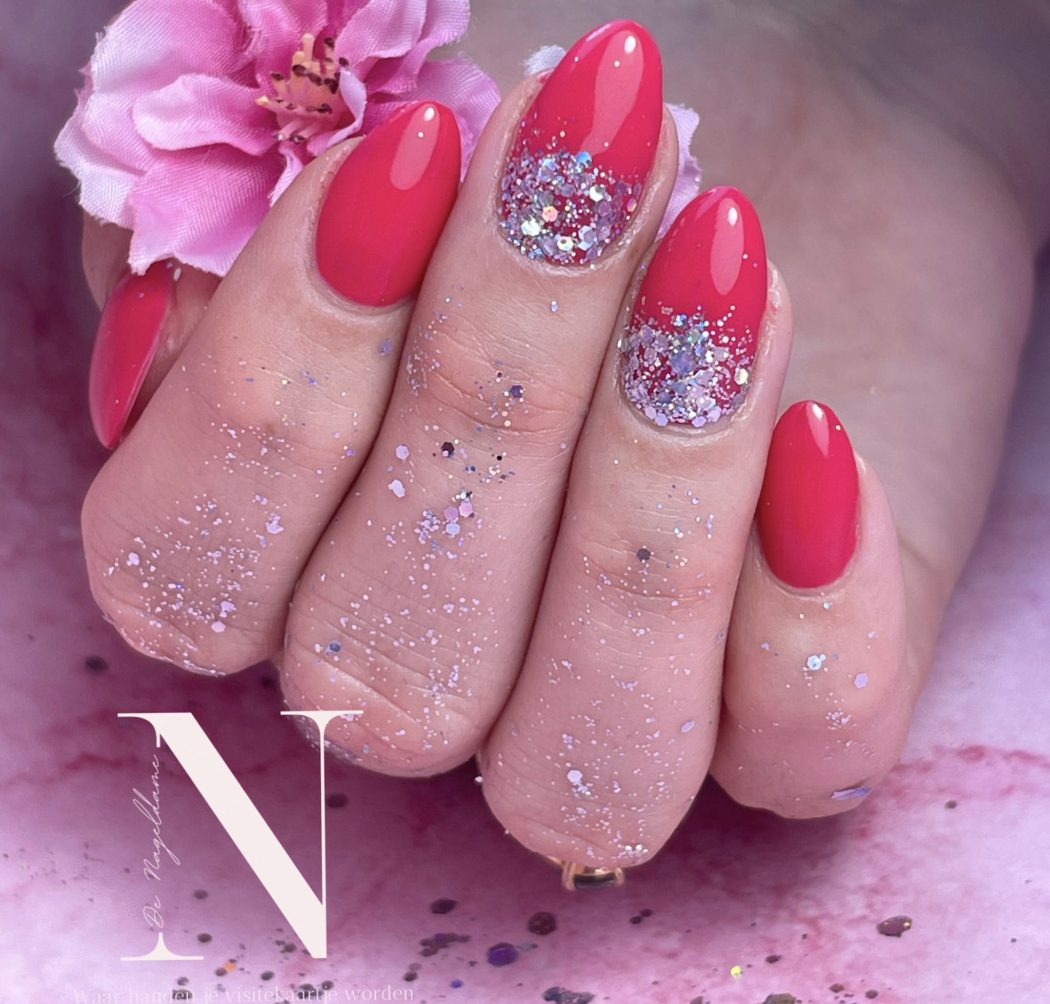 Koraalroze nagels met glitter en een roze bloem